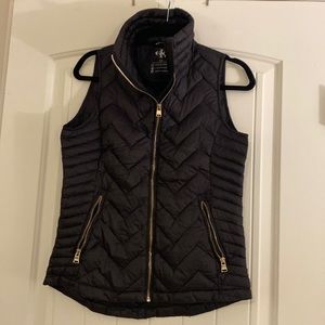Calvin Klein women’s black puffer vest size Small with gold zippers.